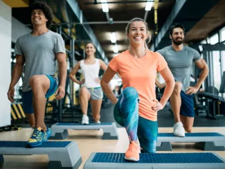 Frau im Fitnessstudio beim Trainieren in einer Gruppe