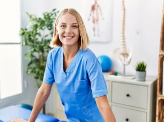 Blonde Physiotherapeutin in an der Massagebank